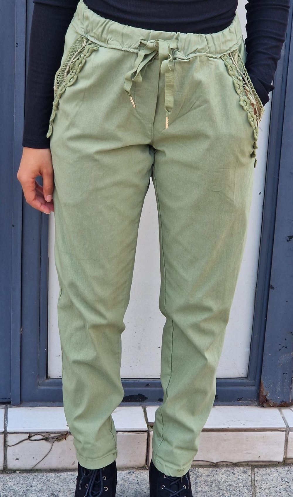 Pantalon de couleur vert. Broderie à fleurs sur les deux poches avant du pantalon. Possède des poches arrières également.